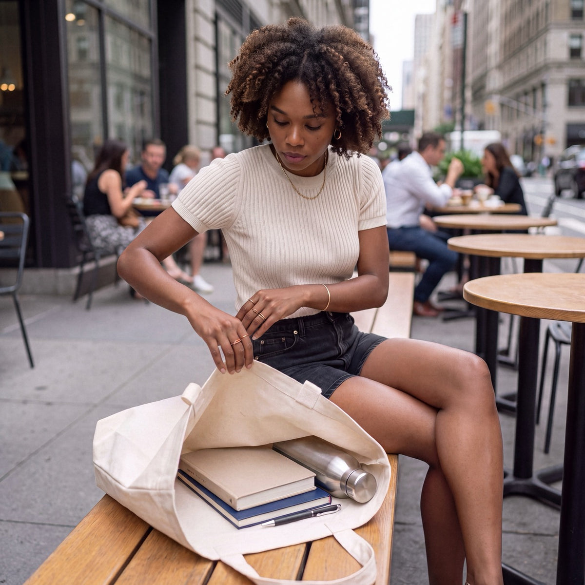 Woman sitting outdoors with a Natural Raw Department of Overthinking embroidered tote bag