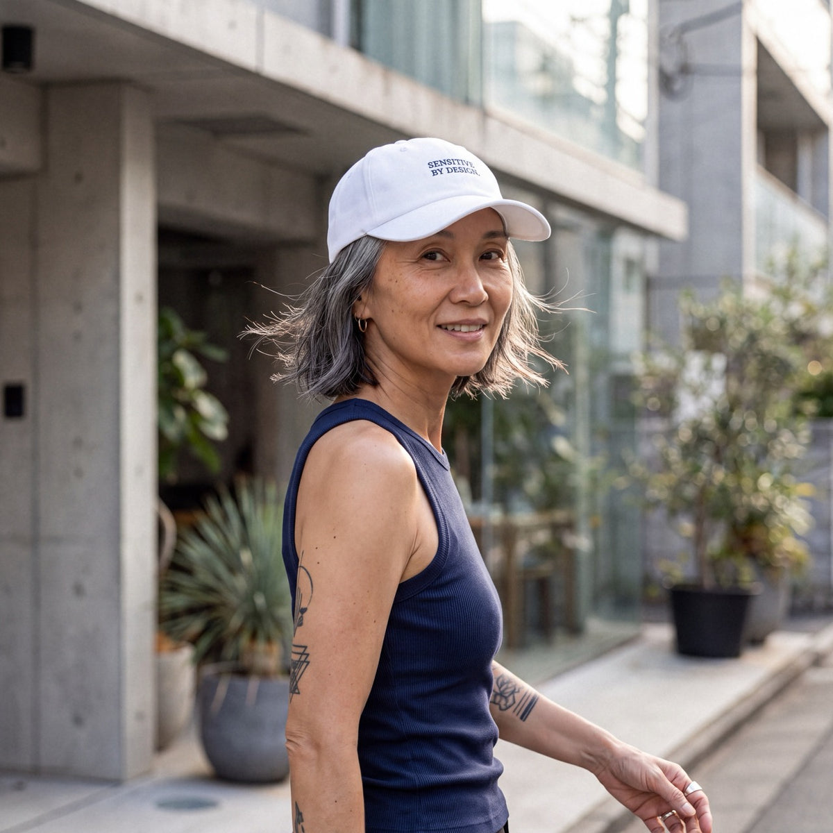 Woman wearing a white Department of Overthinking cap outdoors