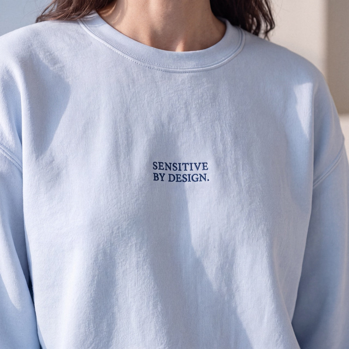 Close-up of light blue Department of Overthinking embroidered sweatshirt