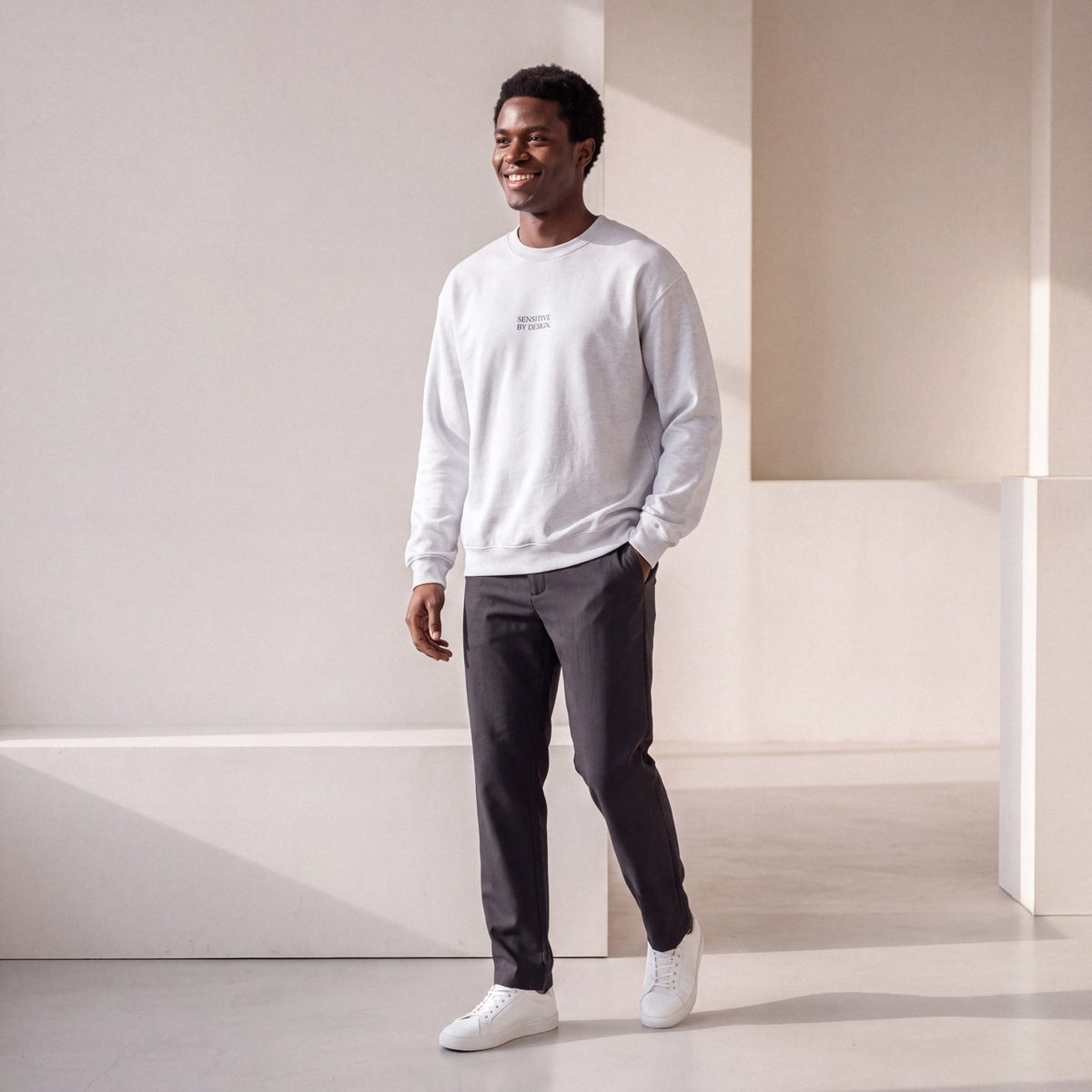 Front view of man wearing an ash SENSITIVE BY DESIGN. sweatshirt