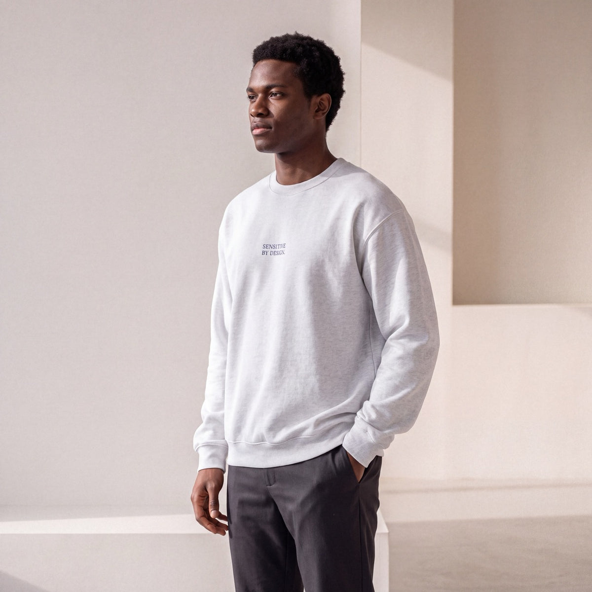 Side view of man wearing an ash embroidered crewneck sweatshirt